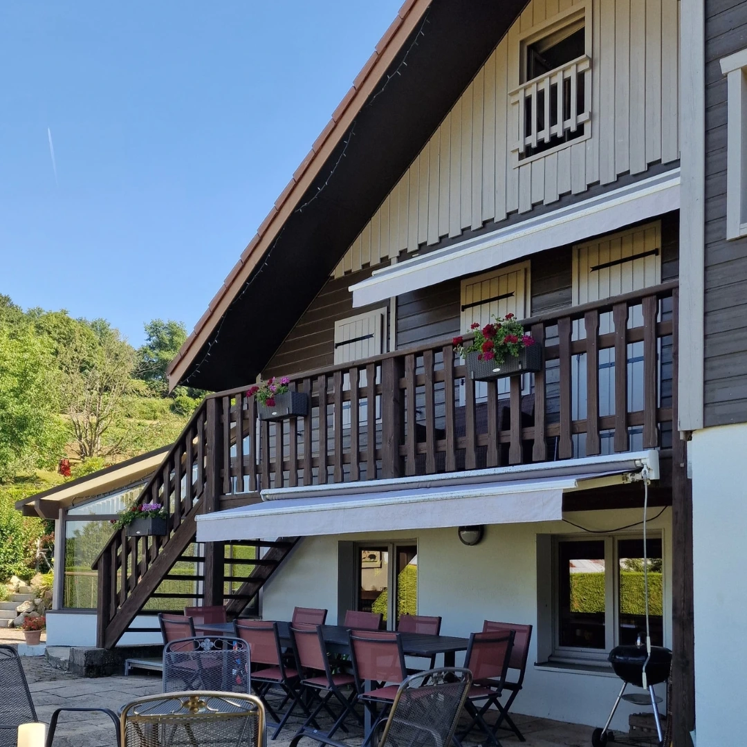 Le Chalet et sa terrasse devant la forêt vosgienne